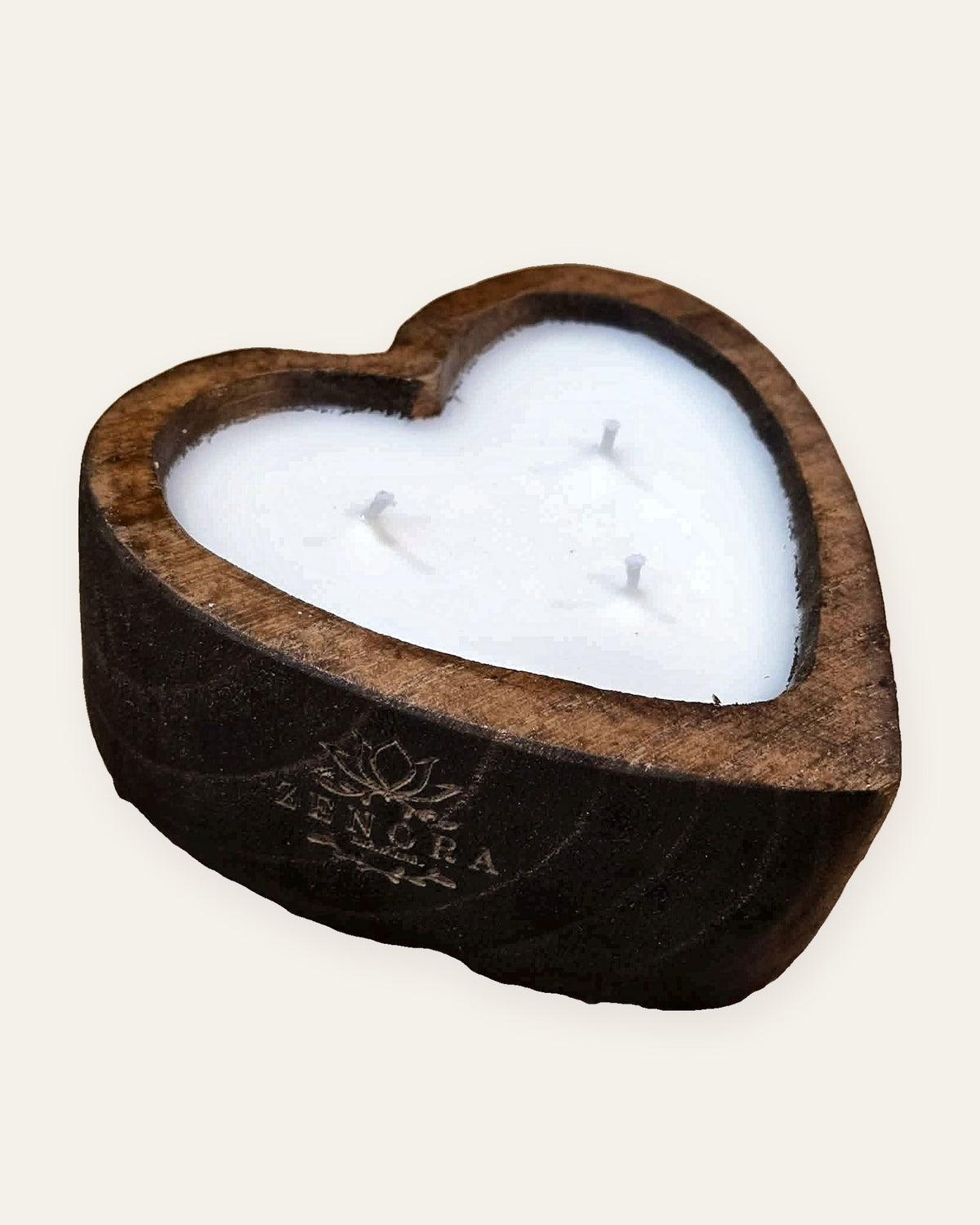 Bougie Zenora dans un bol en bois sculpté en forme de cœur, logo gravé au laser, sur fond clair